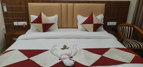 a hotel room with a bed with a teddy bear on it at Hotel MK Grand in Varanasi