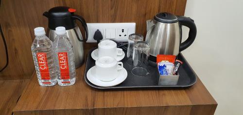 a tray with a coffee maker and bottles of water at Hotel MK Grand in Varanasi