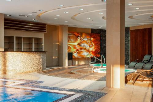 a lobby with a pool and a painting on the wall at Primavera Jastrzębia Góra in Jastrzębia Góra