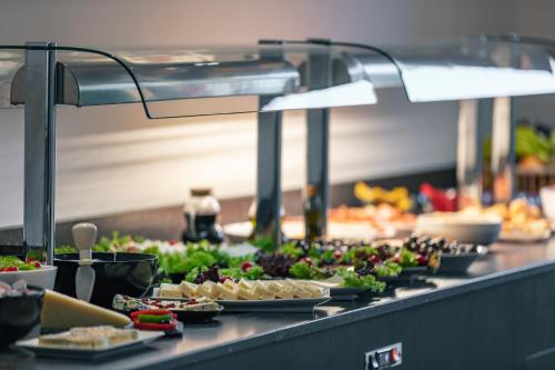 a buffet line with plates of food on a counter at Aristea Hotel in Rethymno Town