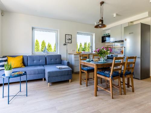 ein Wohnzimmer mit einem blauen Sofa und einem Tisch in der Unterkunft Dom nad Zatoką in Puck