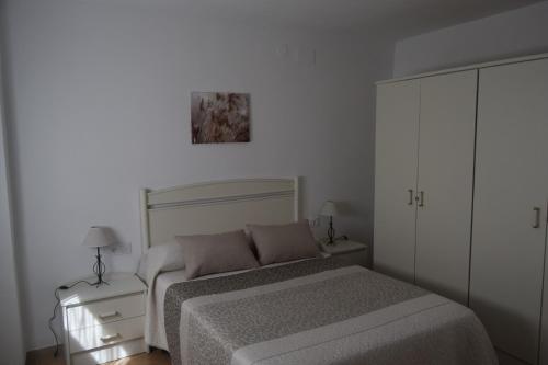 biała sypialnia z łóżkiem i szafką w obiekcie CASA DEL VIDRIO w mieście Castril