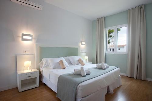 1 dormitorio con 1 cama blanca grande y 2 almohadas en Apartamentos Vista Alegre Mallorca, en Porto Cristo