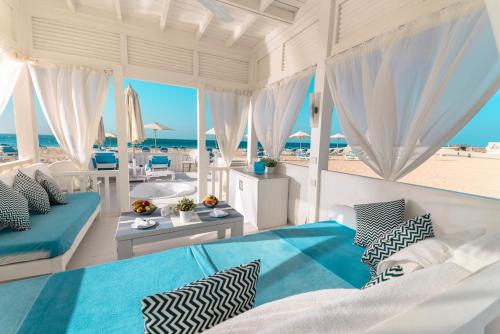 a bedroom with a bed and a view of the beach at Rixos Alamein - Full Board Plus in El Alamein