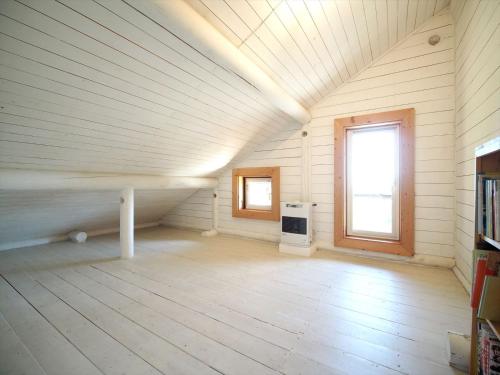 a large room with a wooden floor and a window at Minanonno Play Village in Yoichi