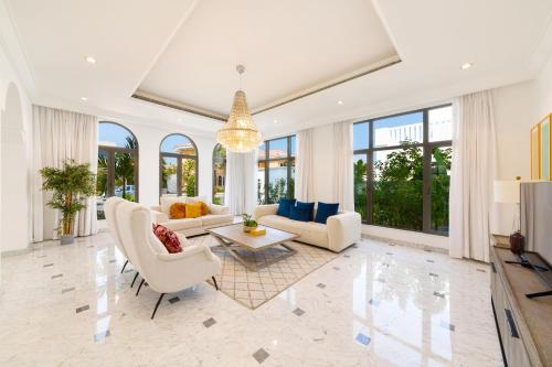a living room with white furniture and large windows at Maison Privee - Luxury Villa with Dramatic View Private Beach & Pool in Dubai