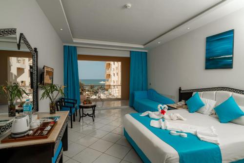 a bedroom with a bed and a living room at King Tut Aqua Park Beach Resort in Hurghada