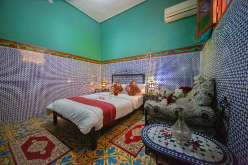 a bedroom with a bed and a chair in a room at Maison Adam in Fez