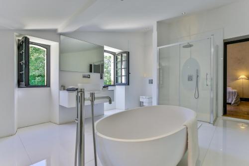 y baño blanco con bañera y ducha. en CHATEAU DE LASCOUPS, en Saint-Martin-des-Combes