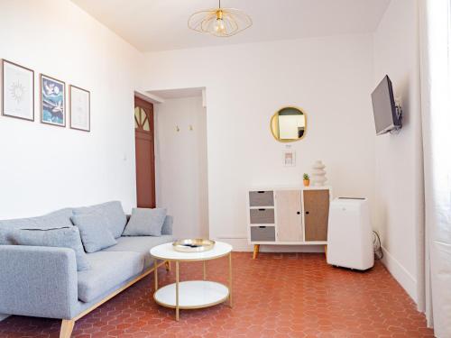 a living room with a blue couch and a table at Le Cocoon - Appartement cocooning à Orange in Orange