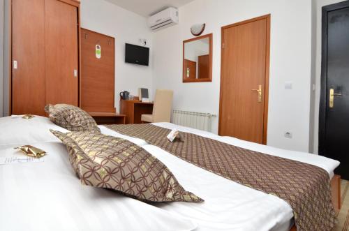 a bedroom with a large bed with two pillows at Hotel Neboder in Rijeka