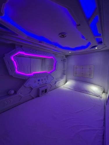 a small room with a bed with purple lights at Destino Cobisa in Cobisa
