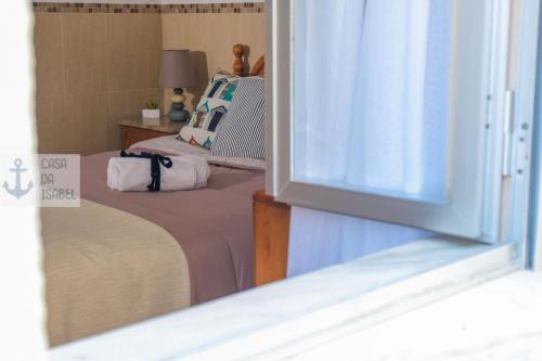 ein kleines Schlafzimmer mit einem Bett und einem Fenster in der Unterkunft Casa da Isabel - Centro da Nazaré in Nazaré