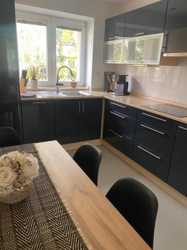 a kitchen with a wooden table and a counter top at Apartmán Višňovka in Pardubice