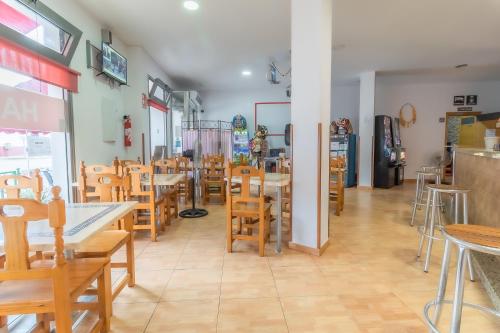 un restaurante con mesas de madera y sillas en una habitación en Albergue Rojo Plata en Torremegía