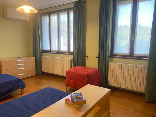 Zimmer mit 2 Betten, einem Tisch und Fenstern in der Unterkunft Cascina Cavalli Astino in Bergamo