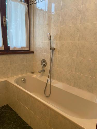 eine Badewanne mit Dusche im Bad in der Unterkunft Cascina Cavalli Astino in Bergamo