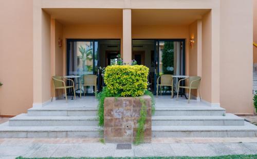 a porch with chairs and a table in a building at PortBlue Club Pollentia Resort & Spa in Alcudia