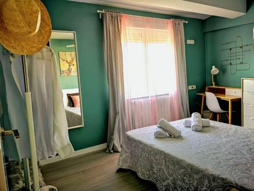 1 dormitorio con cama, espejo y ventana en La balconada de la Aljafería con parking privado en Zaragoza