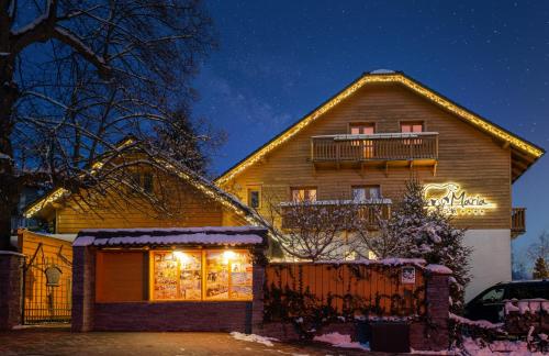 a house with christmas lights in front of it at Penzion Maria in Liptovský Mikuláš