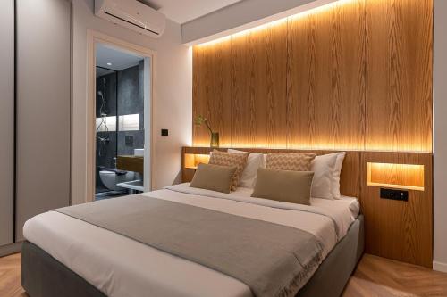 um quarto com uma cama grande e uma parede de madeira em Phaedrus Living Luxury Penthouse Ploutarchou em Atenas