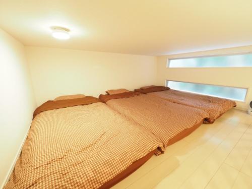 ein Bett in einem Schlafzimmer mit einem großen Fenster in der Unterkunft i home Tsubogawa / Vacation STAY 53028 in Naha