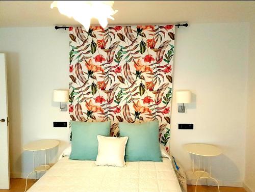 uma cama com uma cabeceira floral com duas almofadas em LHome em Sevilha