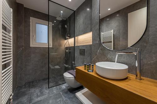 uma casa de banho com um lavatório, um WC e um espelho. em Phaedrus Living Luxury Penthouse Ploutarchou em Atenas