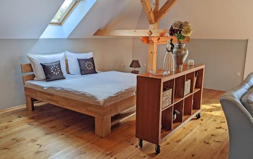 a bedroom with a bed and a wooden floor at Apartmán Brasserie Avion in Rožnov pod Radhoštěm