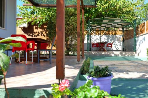 un patio con sillas rojas y una mesa con plantas en Stela Apartments, en Ksamil