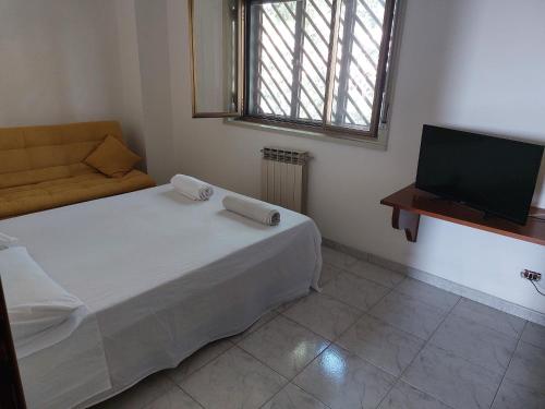 a small bedroom with a bed and a television at Casa Arrigo in Catania