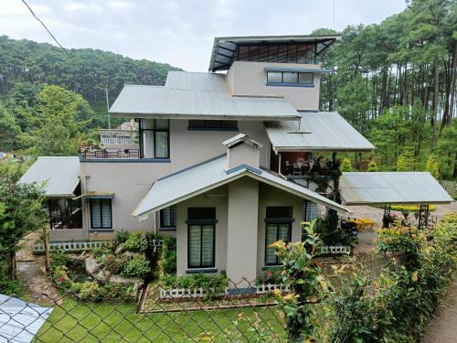 ein Haus mit vielen Fenstern und einem Zaun in der Unterkunft Sha Ri Loum Homestay in Shillong