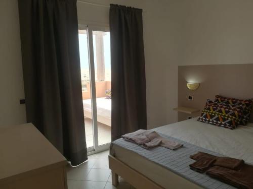 a bedroom with a bed and a sliding glass door at Residence Por Do Sol, Praia Cabral, Boa Vista, Cape Verde, FREE WI-FI in Sal Rei