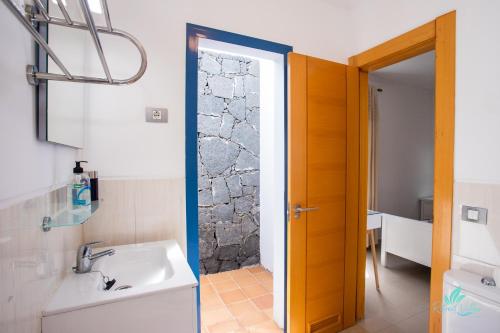 馬西尼古蒂的住宿－Captivating 2-Bed Villa in Playa Blanca，一间带水槽和淋浴门的浴室