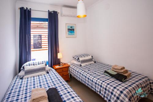 馬西尼古蒂的住宿－Captivating 2-Bed Villa in Playa Blanca，带窗户的客房内设有两张单人床。