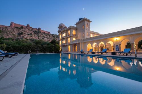uma casa com piscina em frente a um edifício em Mundota Fort And Palace em Pachār