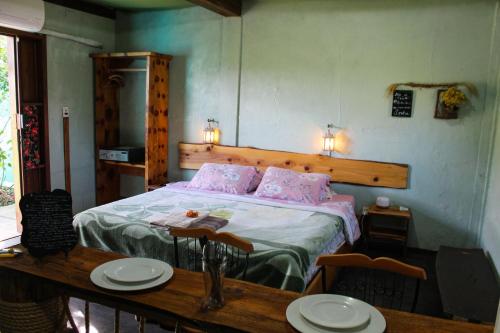 a bedroom with a bed and a table with plates on it at Vila Ecológica Pousada Holística in Cambará