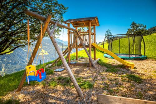 a playground with a slide and a swing set at Lindbichlhof Urlaub am Bio Bauernhof in Sankt Johann im Pongau