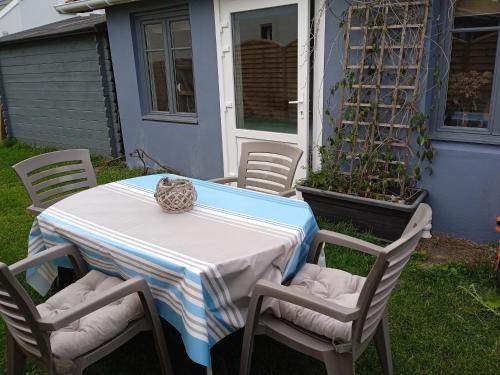 einen Tisch und Stühle auf einem Hof mit einem Tisch in der Unterkunft HOTE MERLIMONT in Merlimont