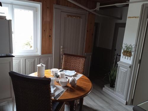 einen Holztisch mit Stühlen, einem Tisch und einem Fenster in der Unterkunft HOTE MERLIMONT in Merlimont