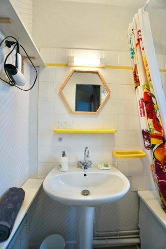 une salle de bain avec un lavabo et un miroir dans l'établissement Le duplex du quai mer, à Concarneau