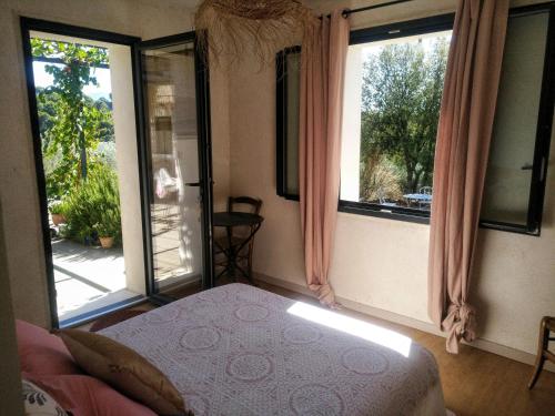 una camera con un letto e due finestre e un tavolo di EtoileduVentoux - Nyons Vaison la Romaine - 2pers a Piégon