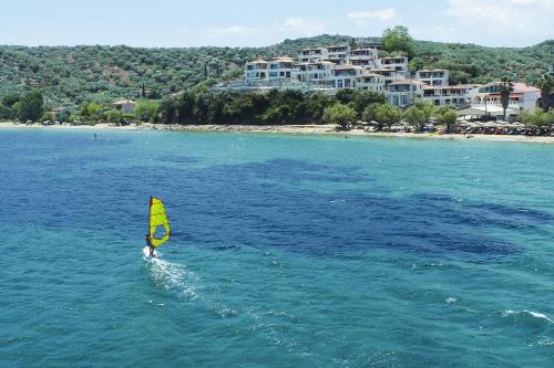 een persoon die windsurft in het water bij een strand bij Olivia Sports and Sea in Pteleós