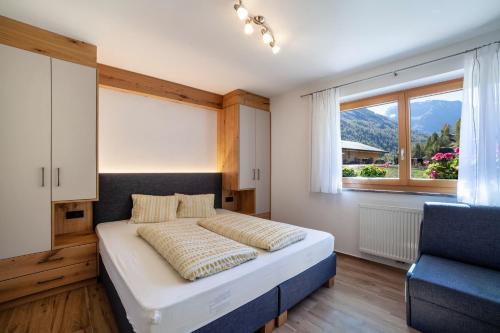 um quarto com uma cama grande e uma janela em Ferienwohnung Lazins em Pfelders