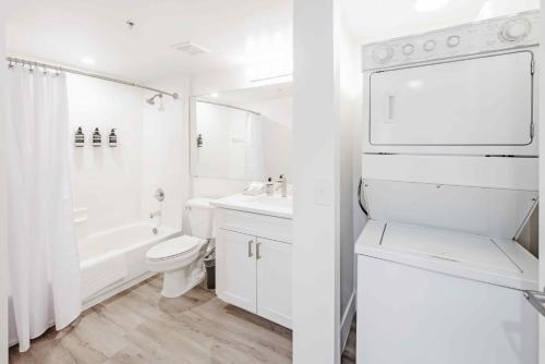 uma casa de banho branca com uma banheira, um WC e um lavatório. em Stunning Centrally Located Apartments at New River Cove in South Florida em Fort Lauderdale