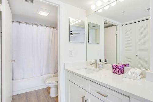 a white bathroom with a toilet and a sink at Tucker at Palm Trace Landings Fort Lauderdale in Davie