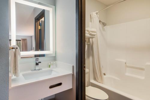 a bathroom with a sink and a toilet and a mirror at Red Lion Inn & Suites Ontario in Ontario