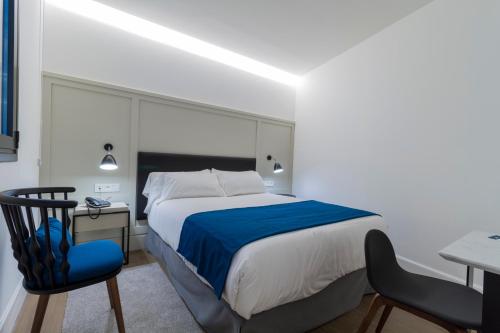 a bedroom with a bed and a desk and a chair at Hotel SANSEbay in Donostia-San Sebastián