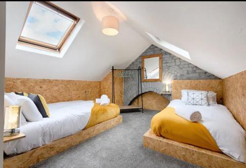 2 camas en un dormitorio ático con 2 ventanas en Groves House Swansea City Centre No pets, en Swansea