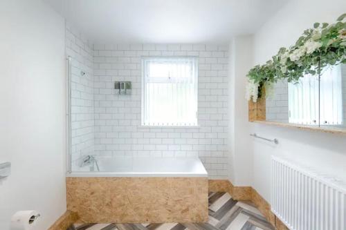 uma casa de banho branca com uma banheira e uma janela em Groves House Swansea City Centre No pets em Swansea